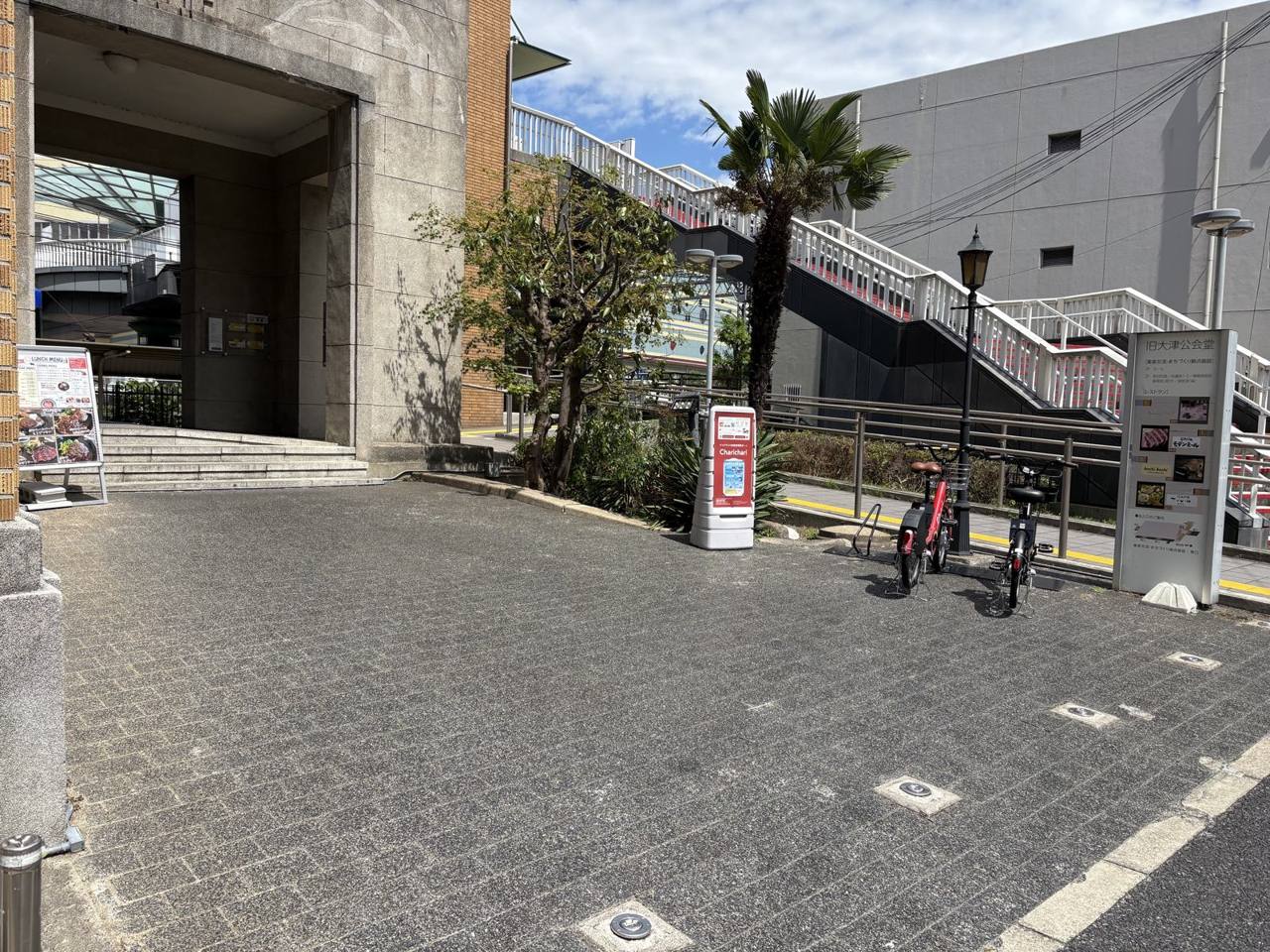前庭の全景。右手にシェアサイクルのポート、両端に他テナントの看板があります