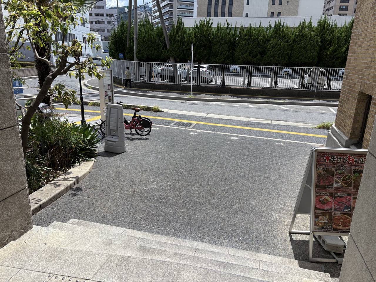 建物側から見た前庭と前面道路。奥に向かって幅が狭くなる台形です